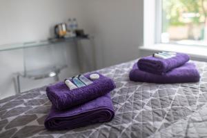 two purple towels sitting on top of a bed at The Norna in Cambridge