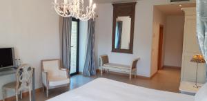 1 dormitorio con 1 cama, 2 sillas y lámpara de araña en Hotel Villa Marcilla, en Marcilla