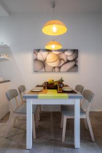 a dining room table with chairs and a painting on the wall at Arco Naxos Luxury Apartments in Naxos Chora