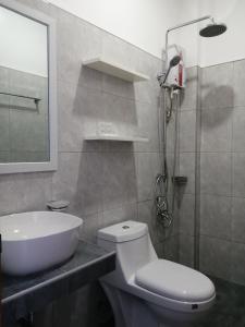 La salle de bains est pourvue de toilettes, d'un lavabo et d'une douche. dans l'établissement Christelle Inn, à Panglao