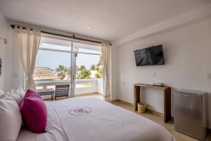 una camera da letto con un letto grande con una grande finestra di Hotel Rockaway a Puerto Escondido