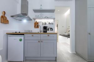 a kitchen with white cabinets and a sink at Arco Naxos Luxury Apartments in Naxos Chora