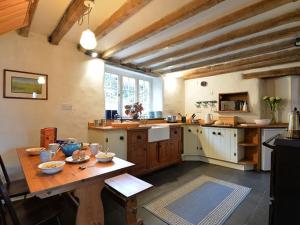 a large kitchen with a wooden table in a room at Pantlleni in Beddgelert