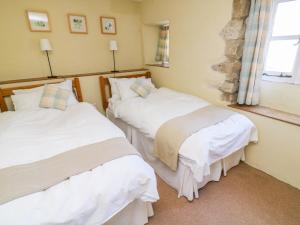 zwei Einzelbetten in einem Zimmer mit Fenster in der Unterkunft Rose Cottage in Skipton