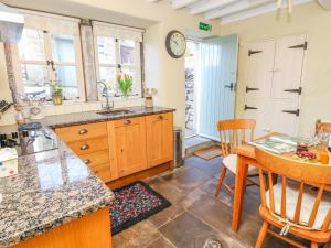 a kitchen with a table and a dining room at Rose Cottage in Skipton
