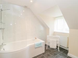 a white bathroom with a tub and a sink at The Donkey Shed in Sherborne +25 photos