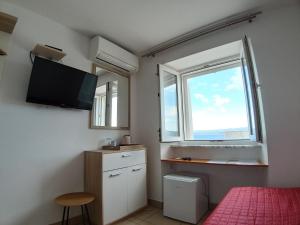 a bedroom with a bed and a window and a television at Riva Rooms in Bol