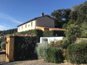 a white house with a fence and bushes at Casa Vacanze "Casale al Pino" in Riparbella