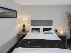 a bedroom with a large white bed with two tables at Quayside in Y Felinheli