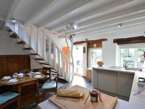 eine Küche und ein Esszimmer mit einem Tisch und einer Treppe in der Unterkunft Rhianfa Cottage in Menai Bridge