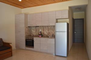 a kitchen with white cabinets and a white refrigerator at Garden View Apartments in Anaxos