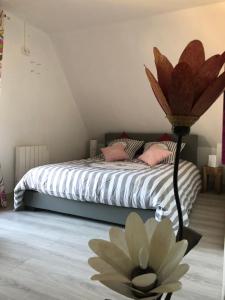 a bedroom with a bed with a flower on the floor at la p’tite chaumière in Forges-les-Eaux