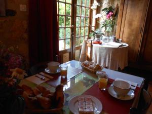 una mesa con comida y bebidas en ella con una mesa con un mantel en CHAMBRES d'HOTES LE ROUSSEL, en Le Buisson de Cadouin
