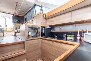 a kitchen with wooden cabinets and a microwave at SEA-E-O in Lymington