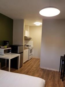 um quarto com uma cozinha, uma cama e uma mesa em Sun Plaza Motel em Sundre