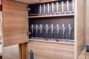 a wine cabinet with wine glasses in it at 2BR Heated Yacht, Lymington Centre, Beautiful View in Lymington
