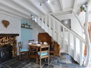 ein Esszimmer mit einem Tisch und einer Treppe in der Unterkunft Rhianfa Cottage in Menai Bridge