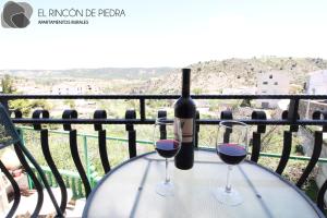 - une bouteille de vin et deux verres sur une table dans l'établissement El Rincon de Piedra, à Enguídanos