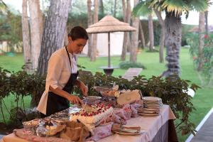 Eine Frau, die einen Kuchen auf einem Tisch schneidet. in der Unterkunft Hotel Gallia & Resort in Lido di Jesolo