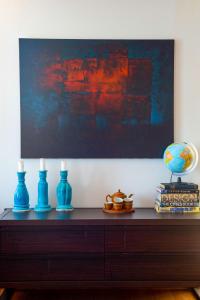 een tafel met twee blauwe vazen en een schilderij bij Sideratos Sea View City Apartment in Chios