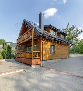 a large wooden house with a large deck at Prie Lukos ezero in Trakai