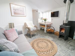 a living room with a couch and a wood stove at Smugglers Cottage in Tintagel