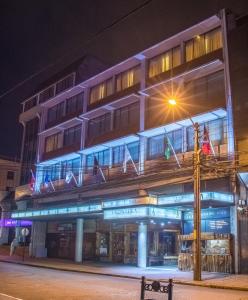 un edificio con banderas en la parte delantera de la noche en Hotel Frontera Clásico, en Temuco