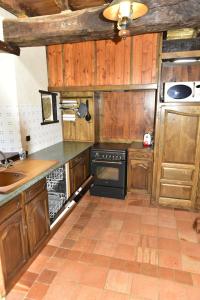 a kitchen with wooden cabinets and a stove top oven at Yourte Roulotte et Gite de la Laïta in Clohars-Carnoët