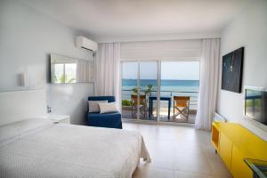 a bedroom with a bed and a view of the ocean at Sideratos Apartments in Karfas