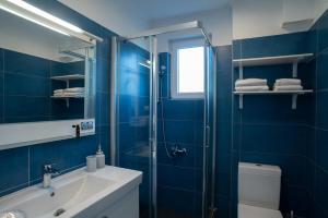 a blue bathroom with a sink and a shower at Sideratos Apartments in Karfas