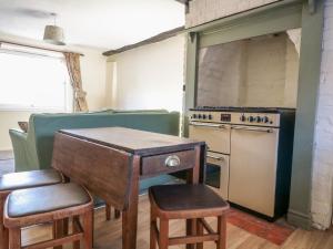 eine Küche mit Tisch und Herd in der Unterkunft River Cottage in Tewkesbury + 13 Fotos