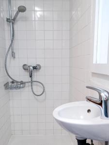 une salle de bain blanche avec une douche et un lavabo dans l'établissement Tiny room Piran, à Piran 5 autres photos