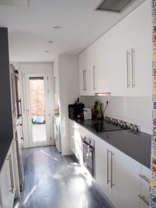 a kitchen with white cabinets and a black counter top at Casa David in Las Negras