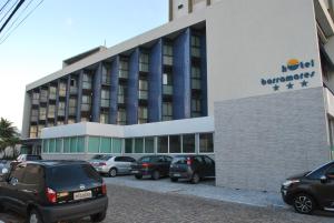 un bâtiment avec des voitures garées devant lui dans l'établissement Hotel Barramares, à Récife