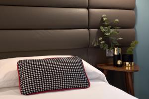 a black and white pillow sitting on top of a bed at Suites Pamplona Plaza in Pamplona