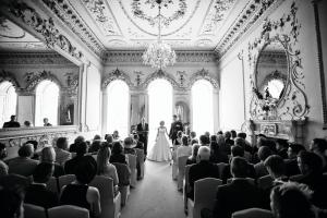 une mariée et un marié se promenant dans l'allée dans une pièce dans l'établissement Plas Nanteos Mansion, à Aberystwyth