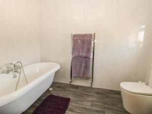 a bathroom with a white tub and a toilet at Willow Lodge in Brough +32 photos