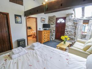 um quarto com uma cama grande e uma parede de pedra em Waterfall Cottage em Caernarfon
