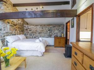 um quarto com uma cama e uma parede de pedra em Waterfall Cottage em Caernarfon