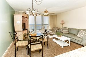 a living room with a table and chairs and a couch at Pelican Pointe in Destin