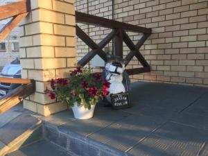 a stuffed animal sitting on a porch next to a plant at Guest house Shchedrino in Yaroslavl