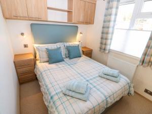a bedroom with a bed with blue towels on it at 4 Lake View in Norwich