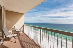 a balcony with chairs and a table and the ocean at Pelican Pointe in Destin