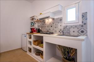 a kitchen with a counter and a sink and a window at Krystalia's Apartment in Plaka Milou +24 photos
