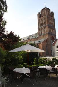
a table with chairs and umbrellas in front of a building at Haus Wullfcrona in Stralsund
