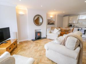 a living room with two white couches and a tv at 14 Tudno Street in Llandudno