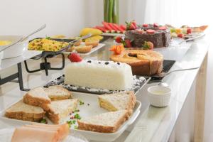a buffet of different types of cakes and desserts at Yucca Pousada in Arraial d'Ajuda