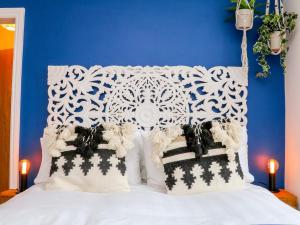a bed with white pillows and a blue wall at SeaSound in Ilfracombe