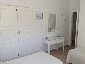 a bedroom with white cabinets and a white table and a bed at Casa Nicho in Vale do Lobo