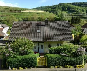 een klein wit huis met een gele poort voor de deur bij Gästehaus Ruländer in Vogtsburg